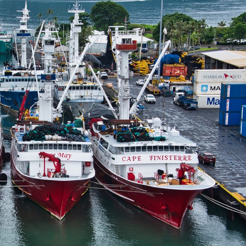 Purse seine fishing vessels and shipping containers at the dock in Pago Pago Harbor