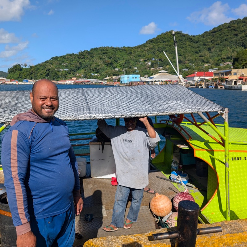 Fishermen aboard a small fishing boat in Pago Pago Harbor